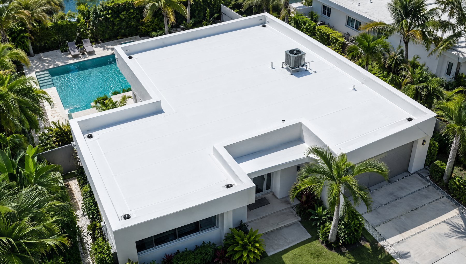 Aerial view of a modern Miami home with a white TPO membrane flat roof, parapet walls and a pool