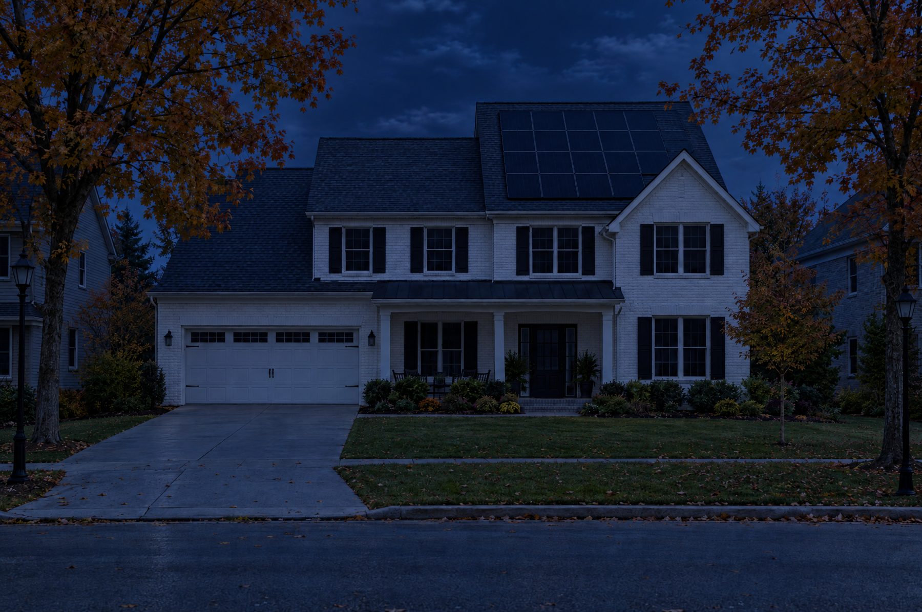 The same street at night during a power outage, every house dark including the one with solar panels