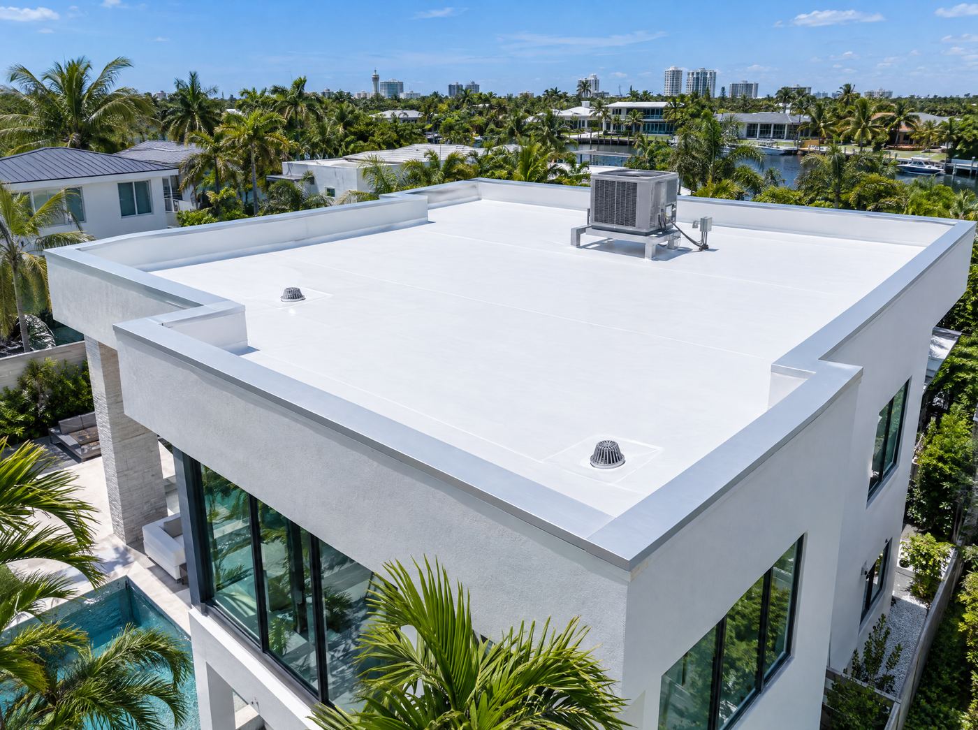 A modern flat-roof Florida home with a new white single-ply roof membrane and parapet walls